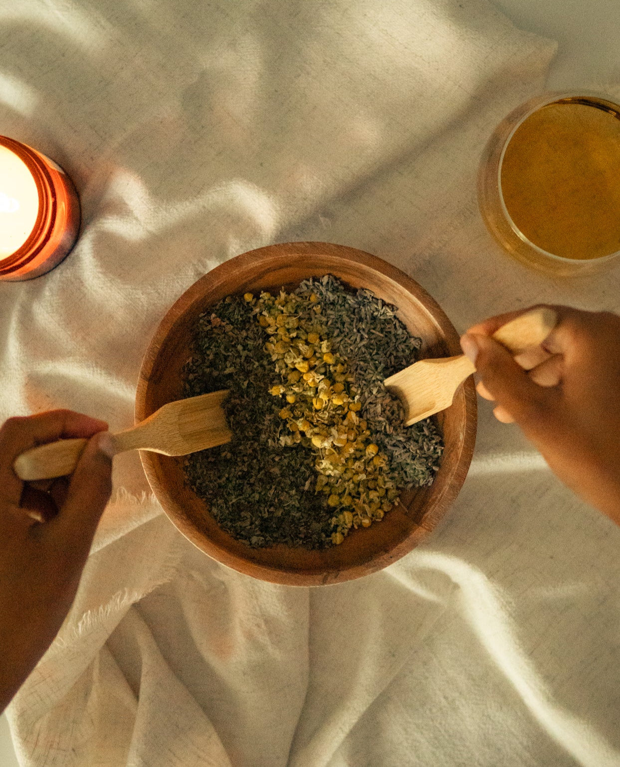 Herbal tea ingredients in wooden bowl – chamomile, lavender, and nettle for cycle support