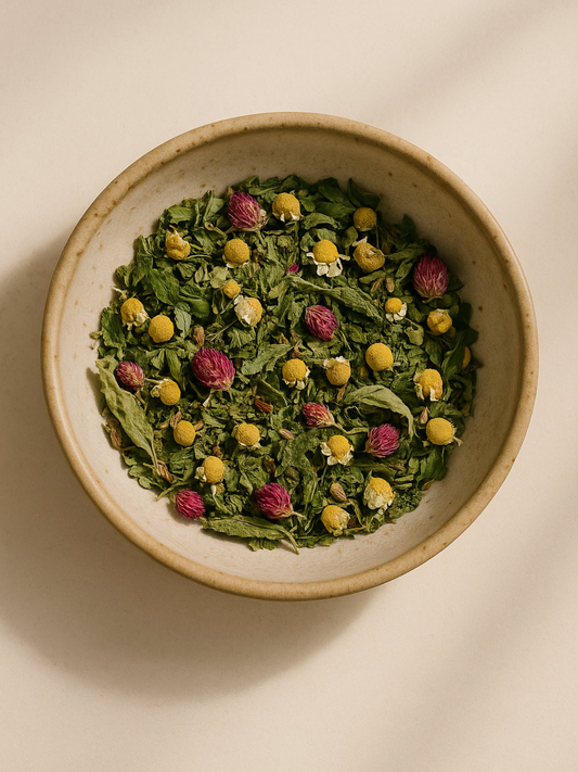 Bowl of dried Glow Tea herbs with chamomile, clover, and nettle leaf